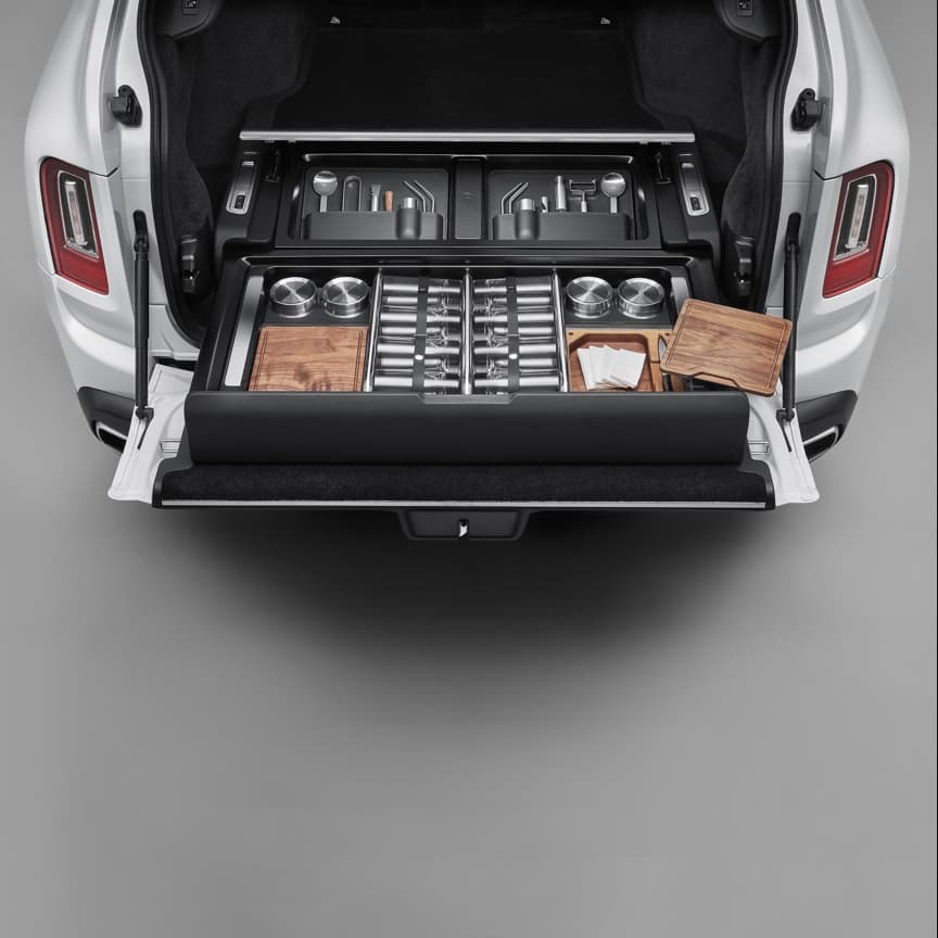 <p>Share unforgettable adventures in the company of friends. The Rolls-Royce Hosting Service offers a range of accoutrements to craft the perfect drink whilst enjoying the world’s most breathtaking vistas with Roll-Royce Cullinan. Delivering effortless luxury everywhere its owner chooses to venture.<br>
<br>
Suited to hosting up to eight adults, the Hosting Service comes complete with glassware and the utensils for creating a fresh cocktail or a classic gin and tonic. Elegant highball glasses are adorned with discreet Rolls-Royce monograms whilst wooden chopping boards are made of the highest quality American walnut. There is space for light snacks to be served alongside the perfect refreshment, whatever your guests’ taste.<br>
<br>
Inside the Hosting Service<br>
<br>
UPPER TRAY LEFT: Leather Pouch, Cocktail Spoons, Four Drinking Straws, Jigger, Ice Tongs, Zester and Muddler.<br>
<br>
UPPER TRAY RIGHT: Leather Pouch, Cocktail Spoon, Four Drinking Straws, Jigger, Bottle OpenerPepper Grinder and Peeler.<br>
<br>
LOWER TRAY: Four Snack Bowls, Eight Highball Glasses, Two Chopping Boards and Paring Knives.<br>
<br>
ADDITIONAL ITEMS: Two Clean Up Towels, Two Clean Up Bags and Eight Napkins<br>
</p>