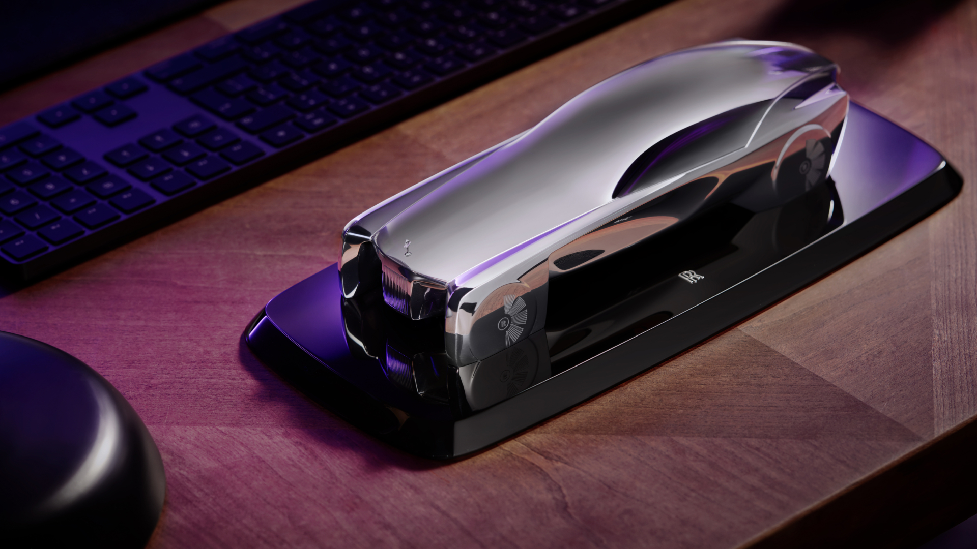 Replica inspired by the Rolls-Royce 'Vision Next 100' car on a desk next to a keyboard for comparison