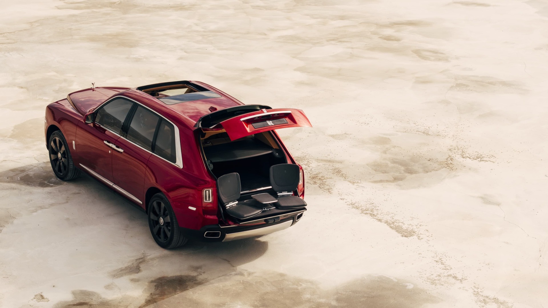 Aerial rear view of stationary Rolls-Royce Cullinan motor car with rear door open revealing the bespoke Cullinan Viewing Suite