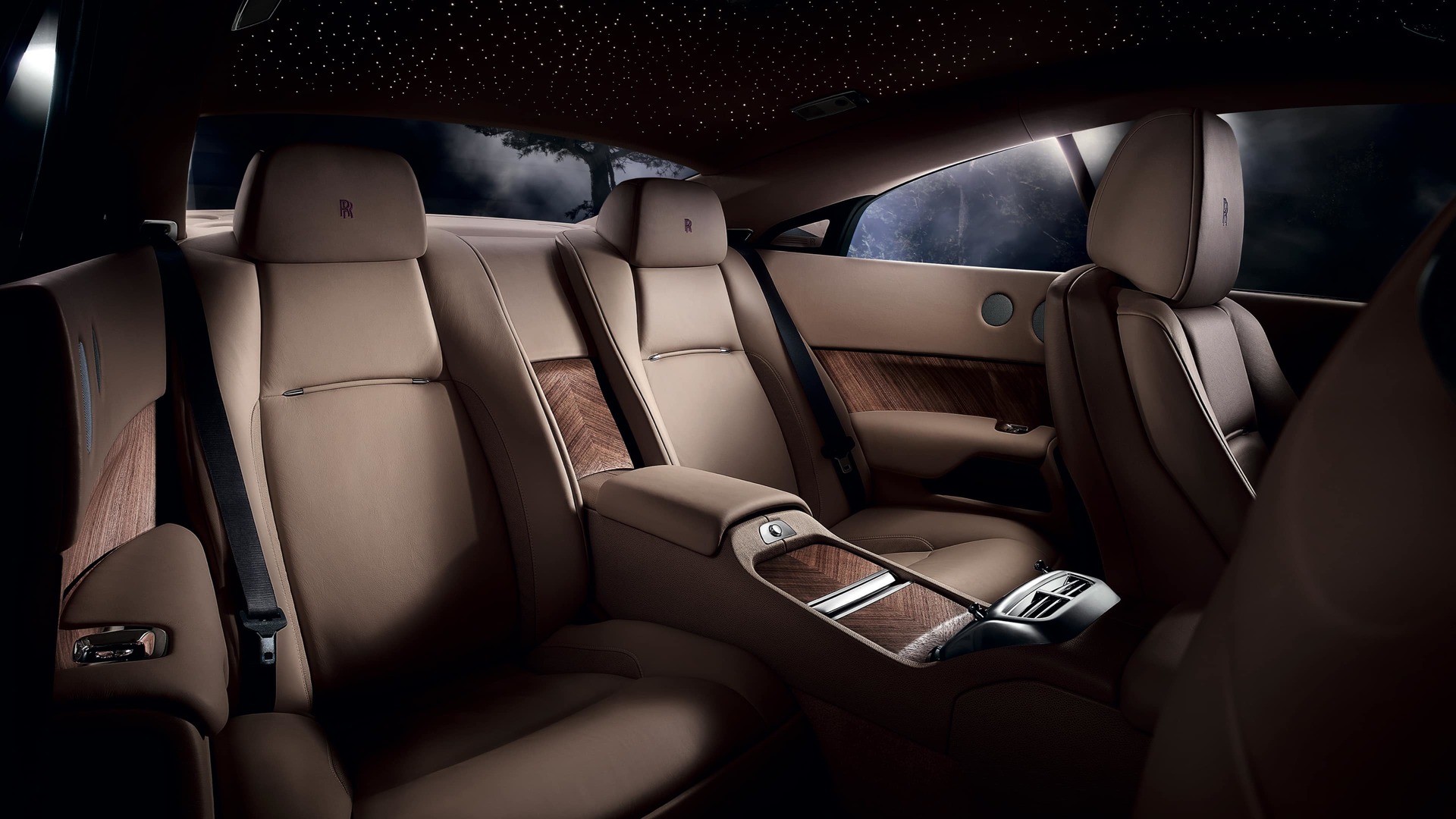 Interior rear cabin seating of Rolls-Royce motor car dashboard and steering wheel of Rolls-Royce motor car with details finished with open grain Canadel wood panelling finish