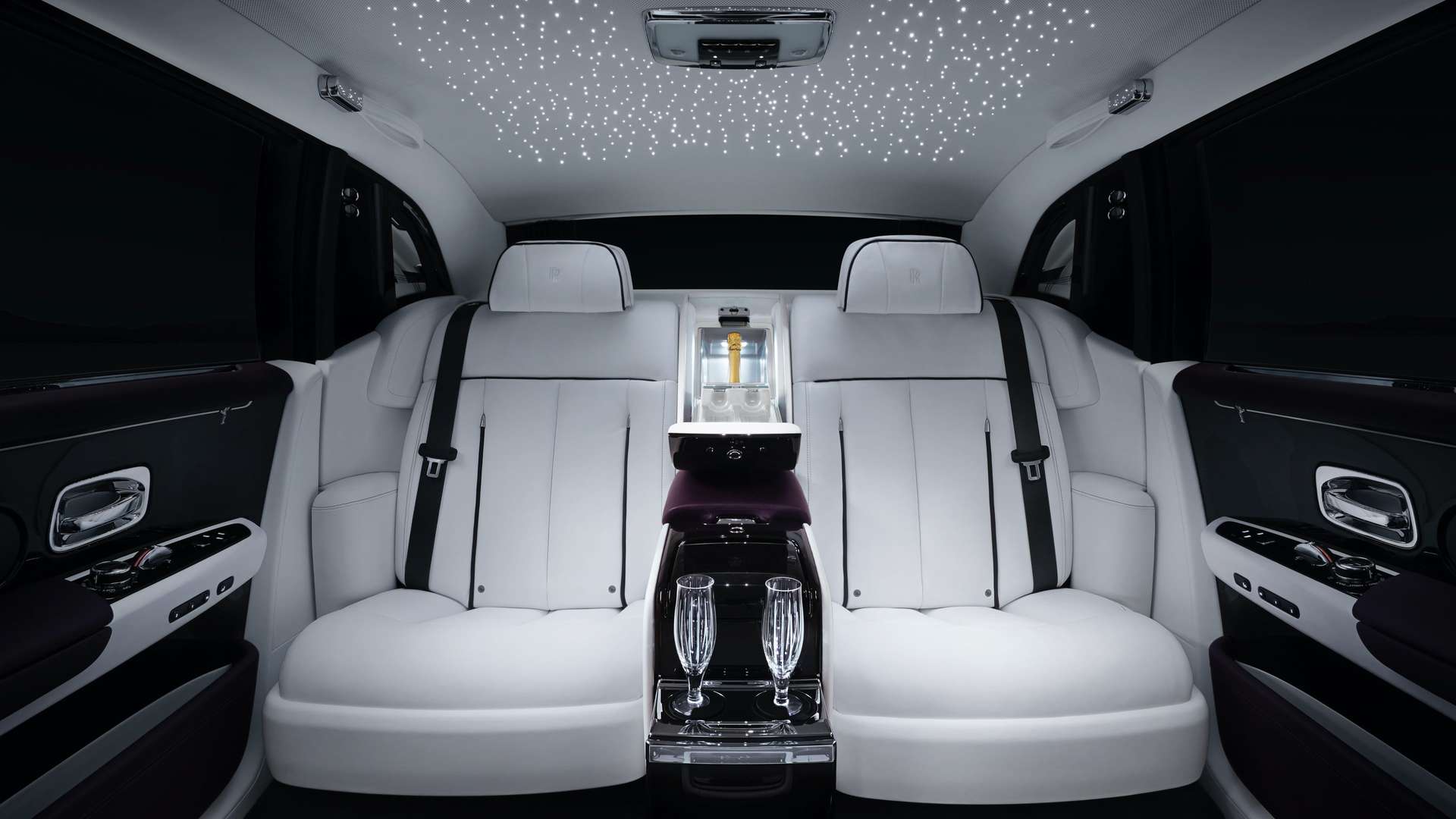 The interior of a Rolls-Royce motor car Ghost with a coolbox and glass holder to secure champagne flutes