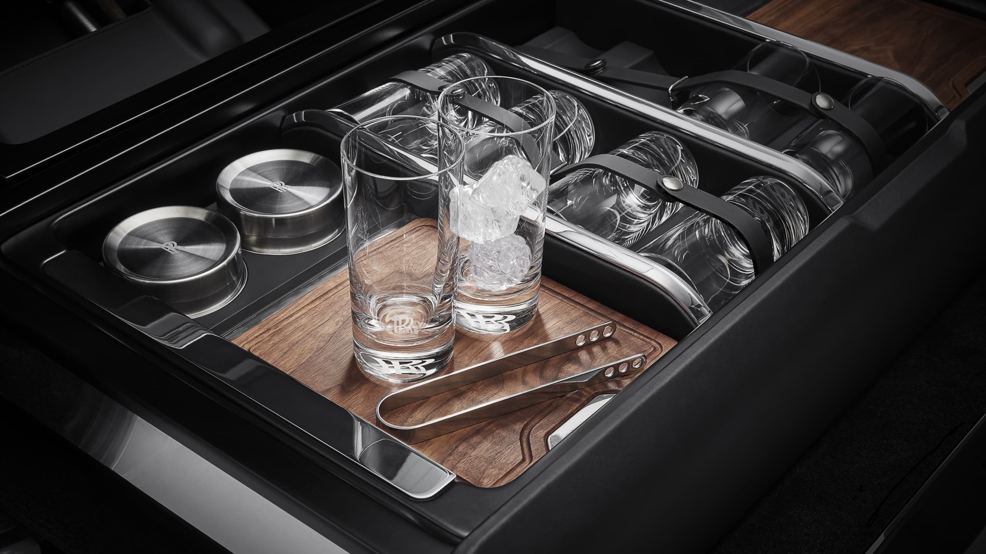 The Rolls-Royce Hosting Service offers elegant highball glasses adorned with discreet Rolls-Royce monograms and wooden chopping boards made of the highest quality American walnut