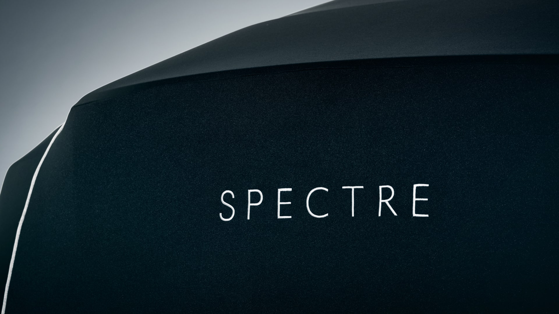 Detailed view of the embroidered Spectre on the back of the Rolls-Royce car cover in black colour