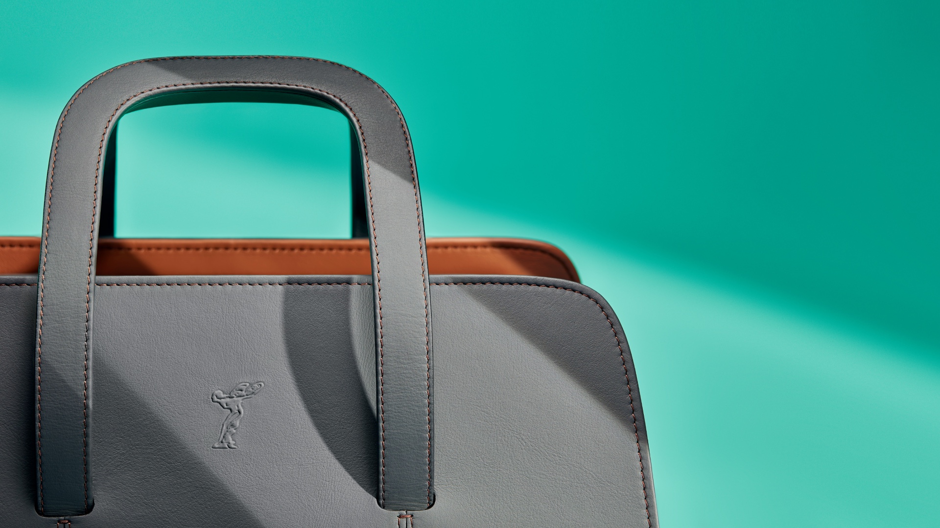 Detail view of the front of the Rolls-Royce Kinetic Luggage Weekender to see the Spirit of Ecstasy on it 