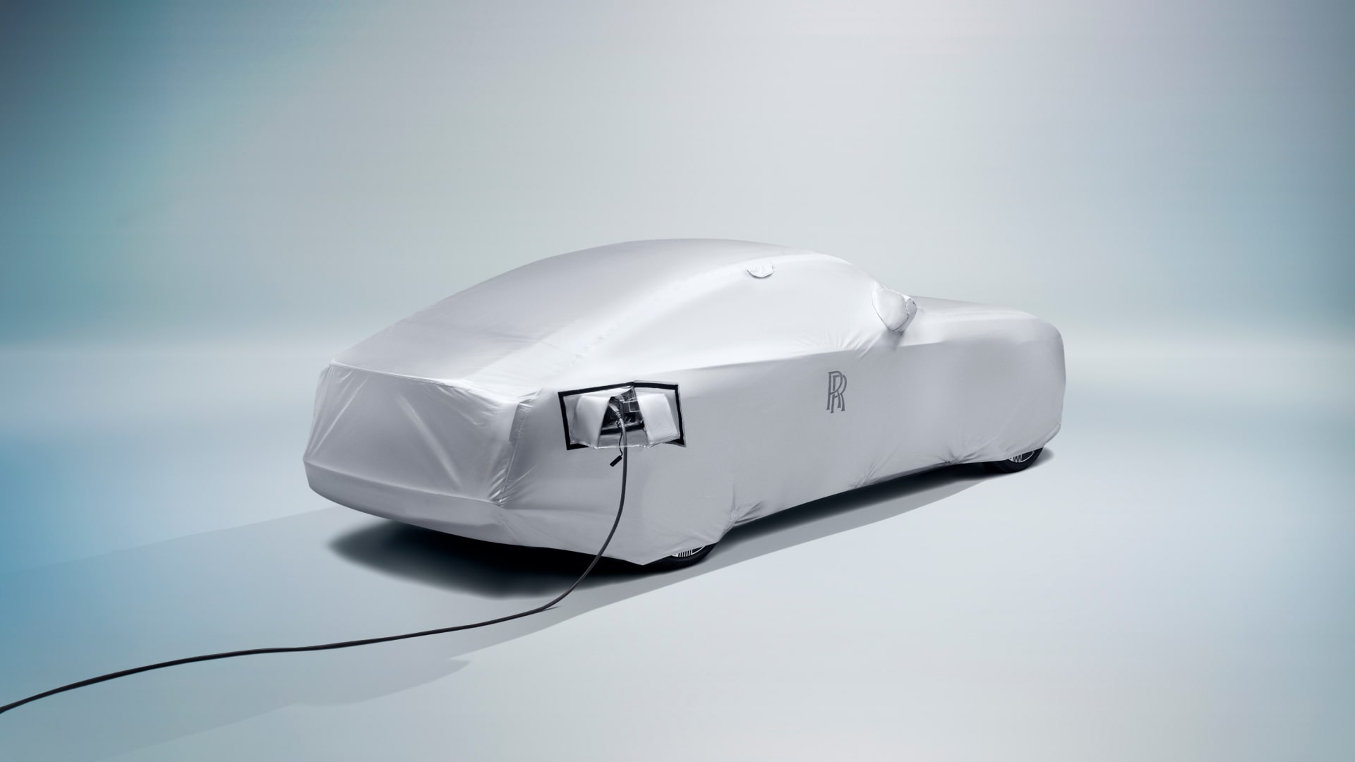 Back view of the Rolls-Royce tailored outdoor car cover in silver colour with the charger connected