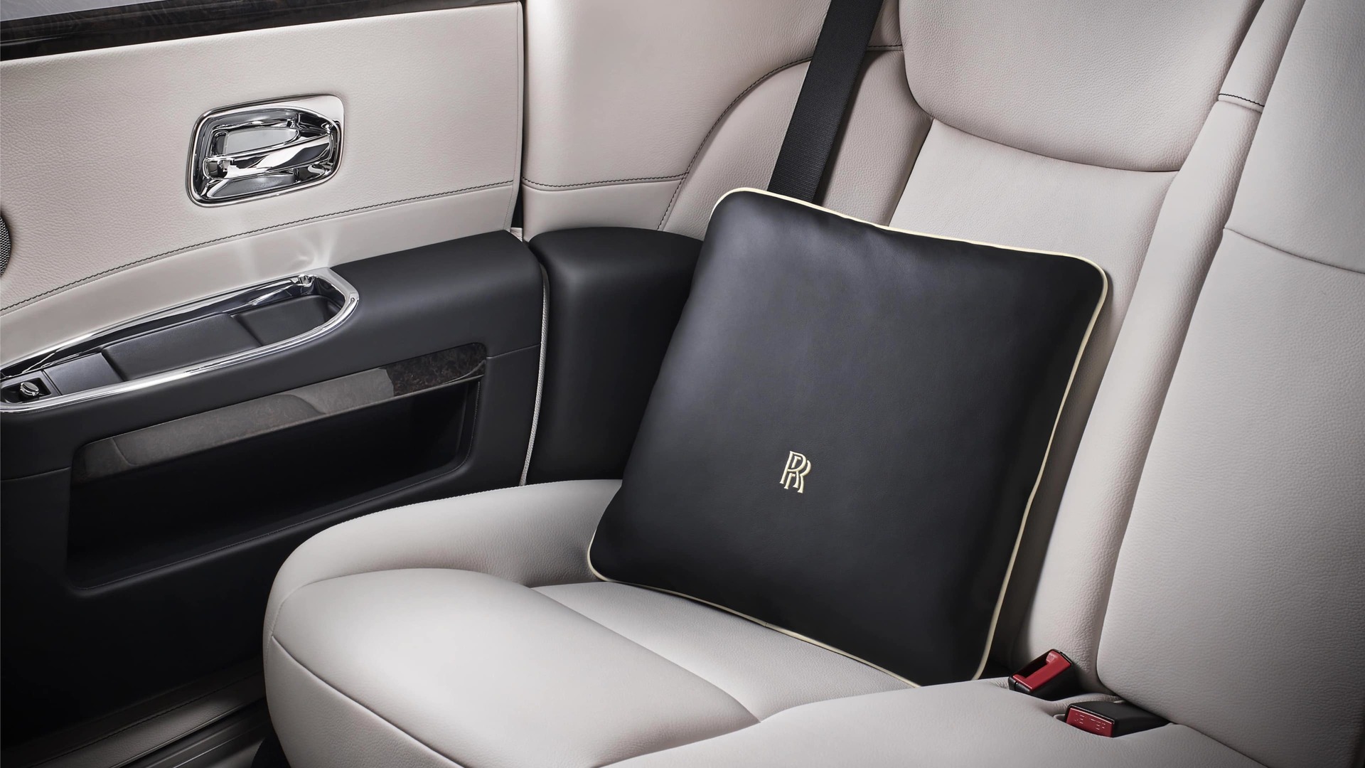 Soft, duck feather Rolls-Royce cushion in black on the rear passenger seat of a Rolls-Royce motor car