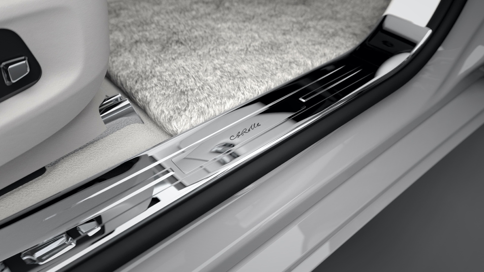 An interior shot of a white Ghost Rolls-Royce Motor Car highlighting the custom engraved treadplate
