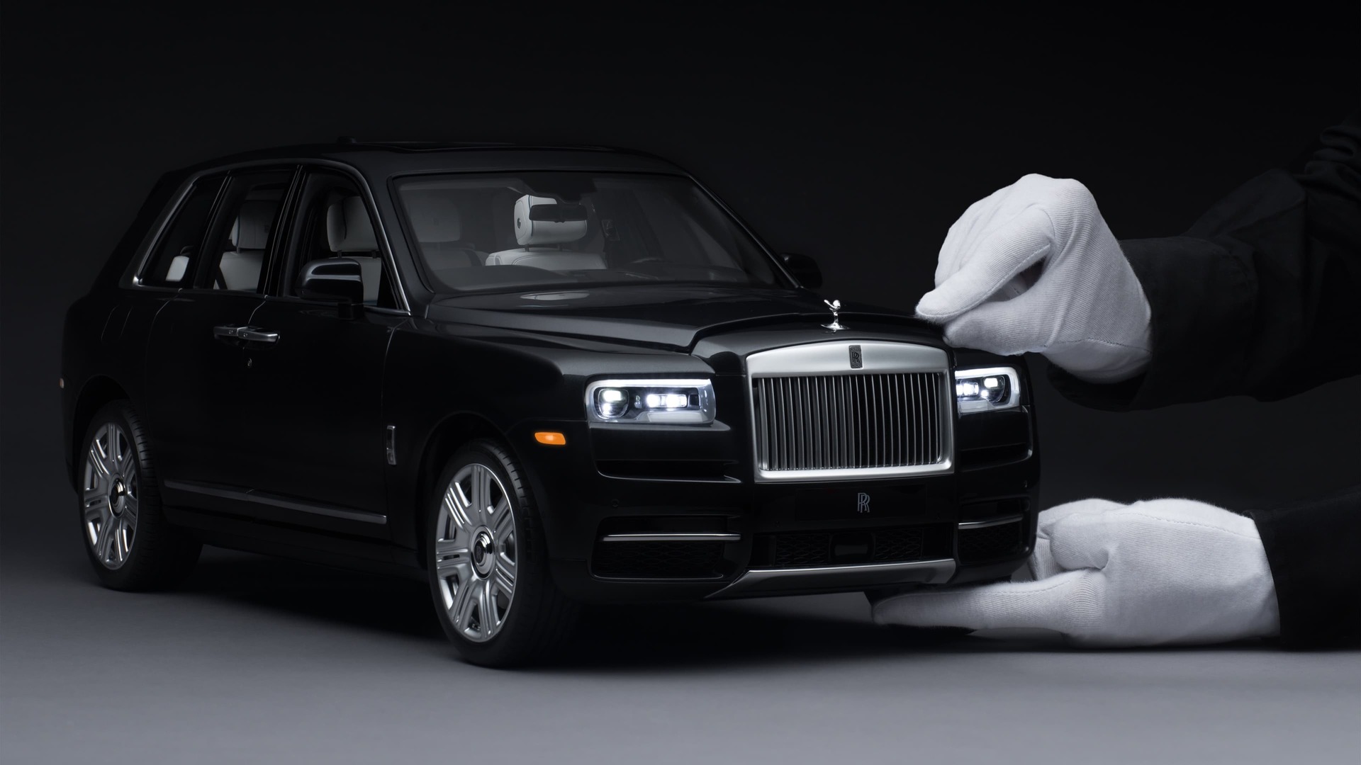 1:8 scale model of the Rolls-Royce Cullinan motor car with hand opening the bonnet