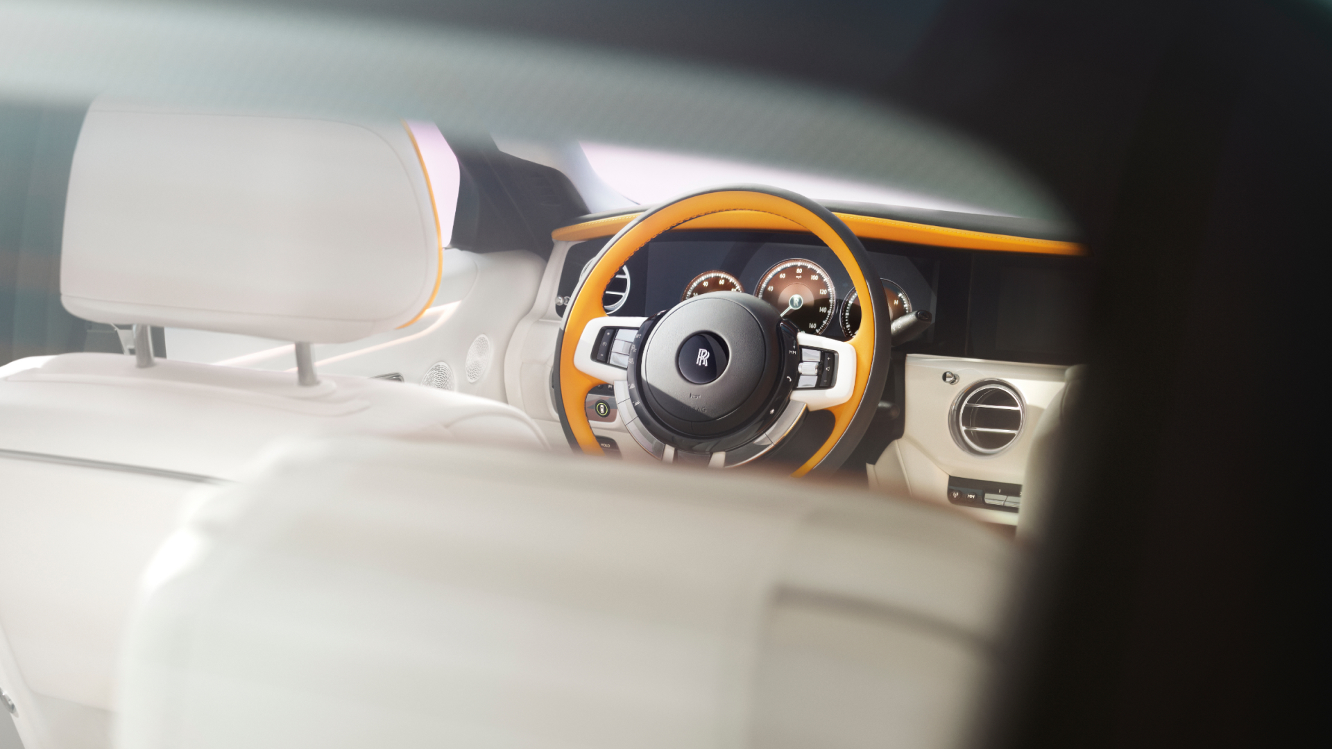 Detailed image of steering wheel inside Ghost with the Rolls Royce logo engraved inside it