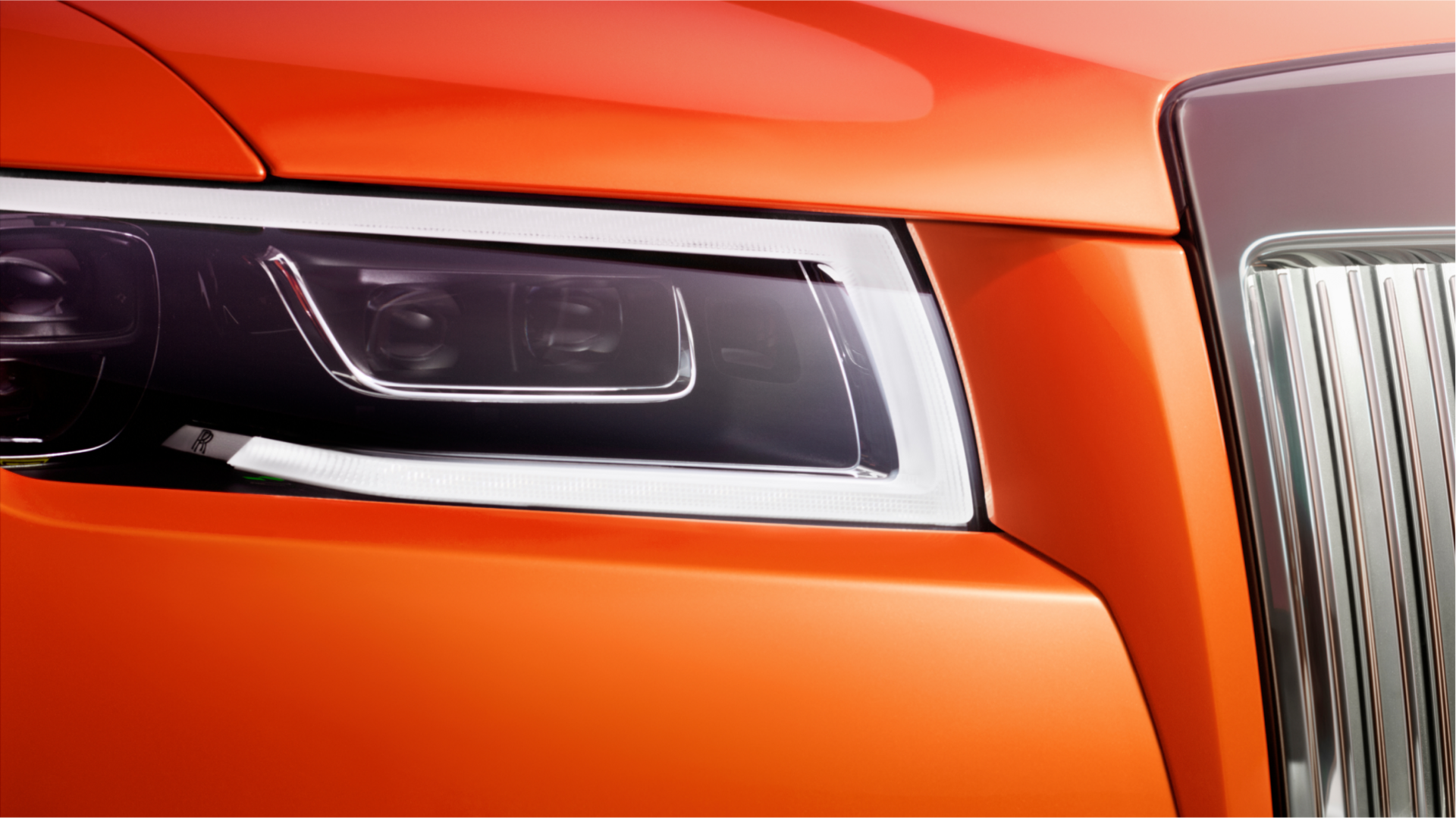 close up of the front headlight turned on of the Orange Metallic Ghost
