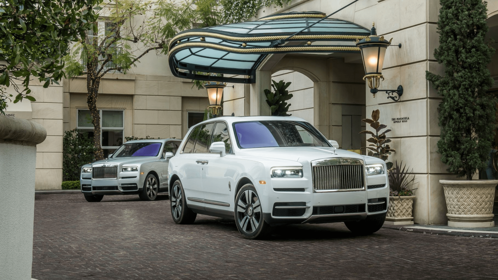 Two Rolls-Royce Cullinan outside a hotel entrance