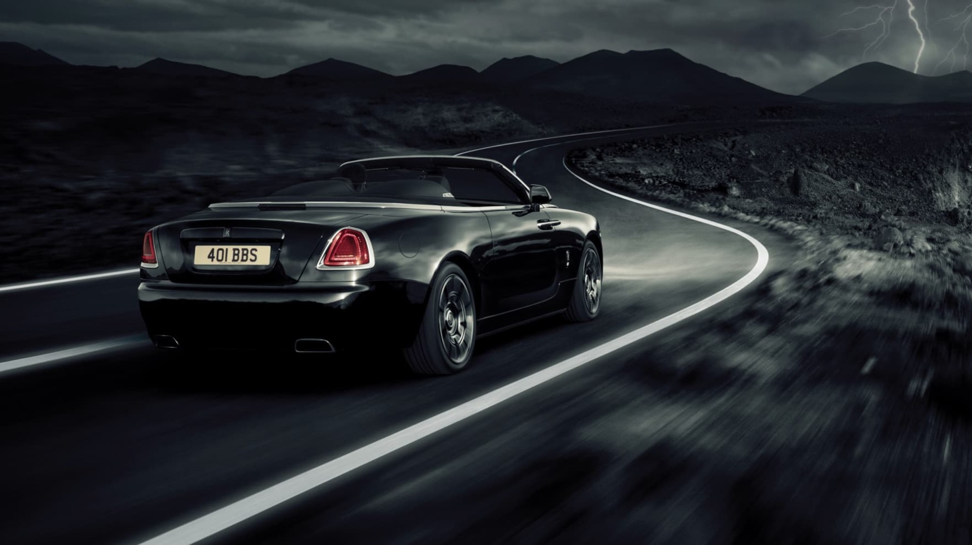 Drophead coupé Rolls-Royce Dawn motor car driving on road at night