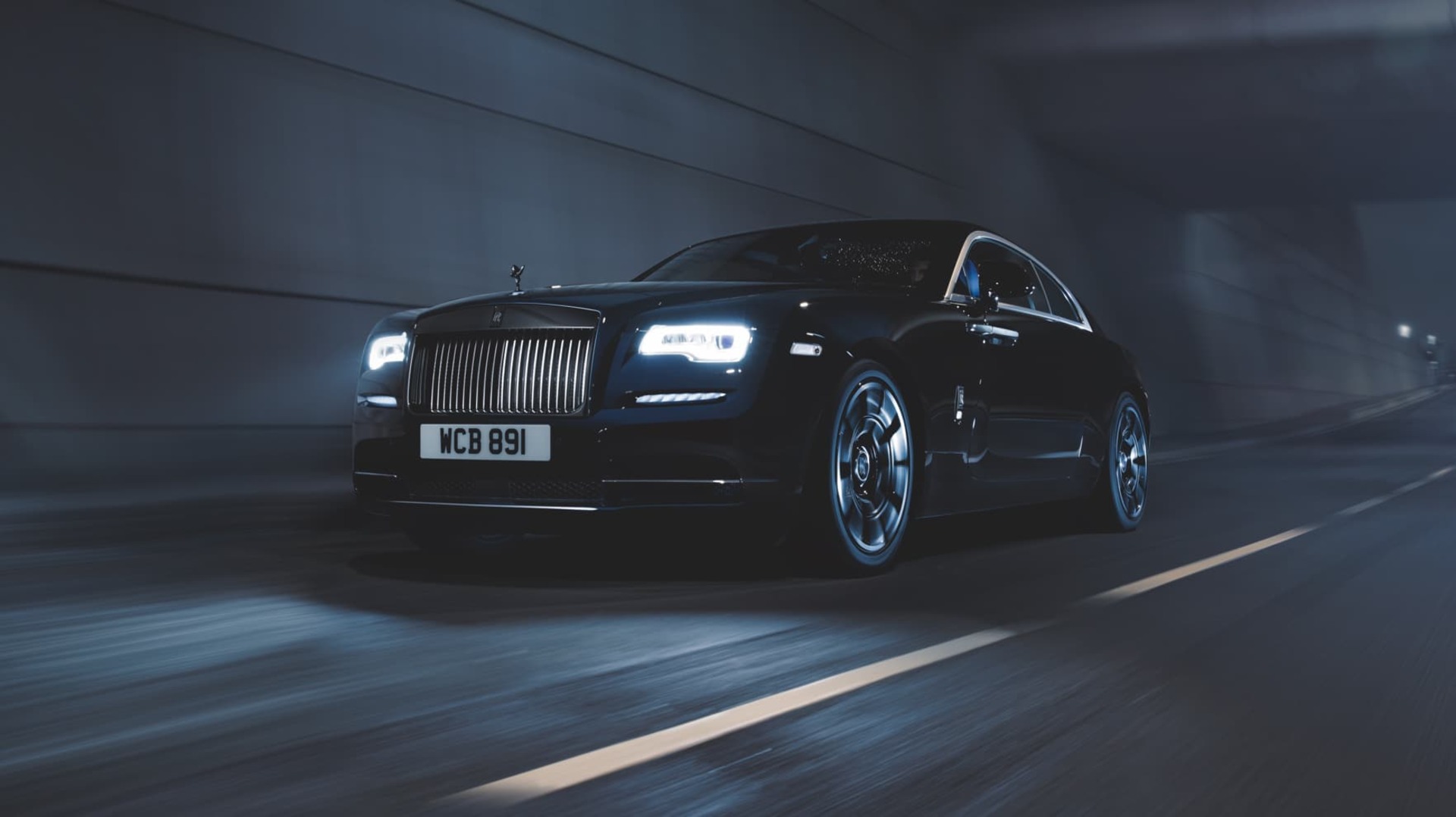 Dynamic 3/4 front exterior shot of Rolls-Royce Black Badge Wraith motor car driving on road