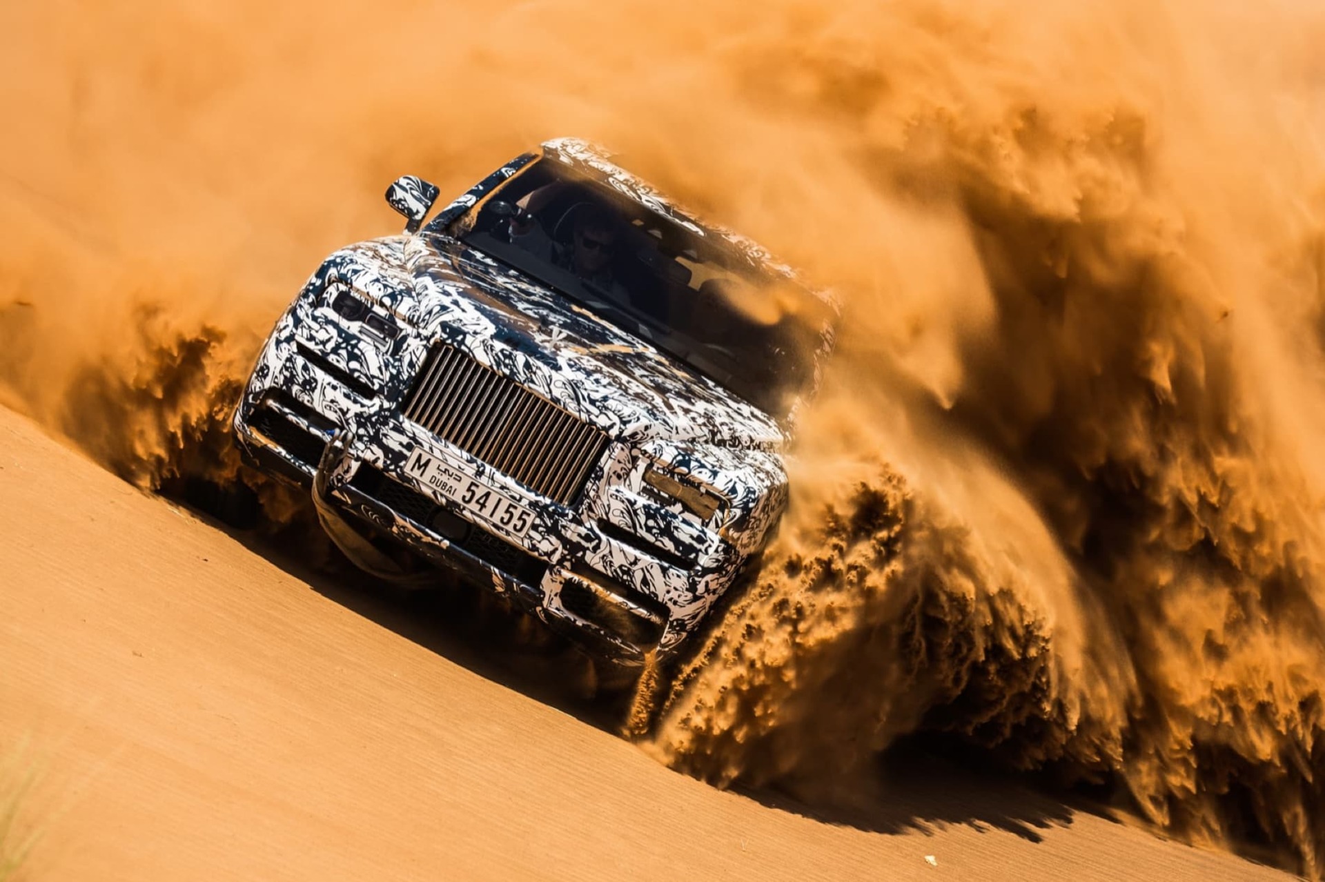 Rolls-Royce Cullinan motor car driving across desert terrain